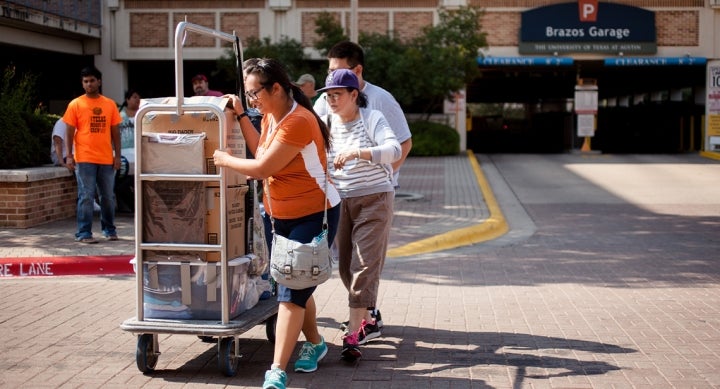 A family transporting belongings from Brazos Garage in a dolly during Mooov-In