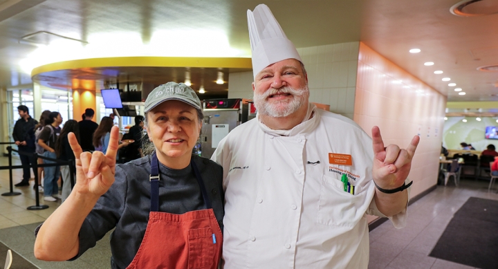 Two chefs pose with hook em hands in J2 Dining