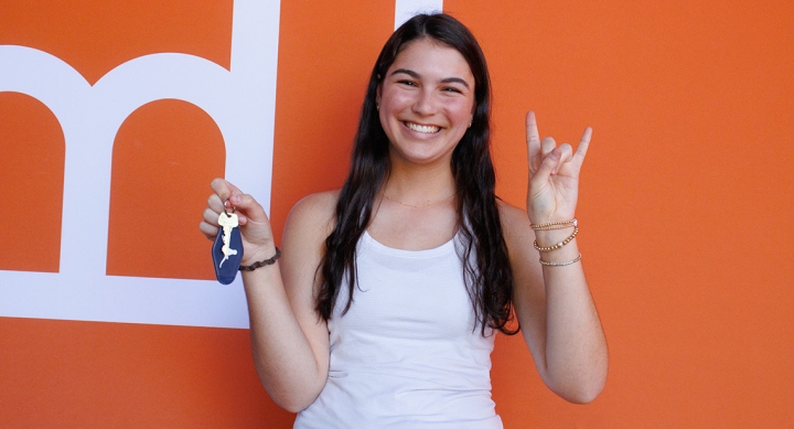 A UT student poses while holding keys at Mooov-In