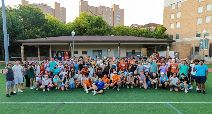 Group of UT students posing with Hook ‘em hand sign at Caven Lacrosse and Sports Center at Clark